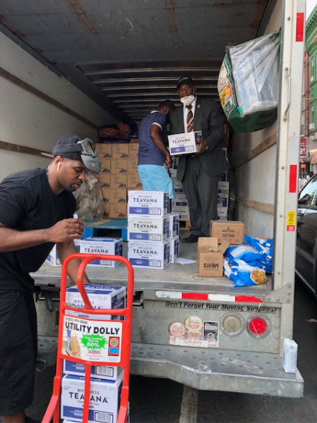 Unloading a truck of food to divide it up and hand out to the community. 